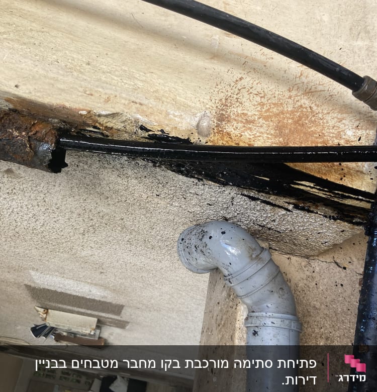 צינור מתכת חלוד עם נזילה ושפיכת נוזל שחור